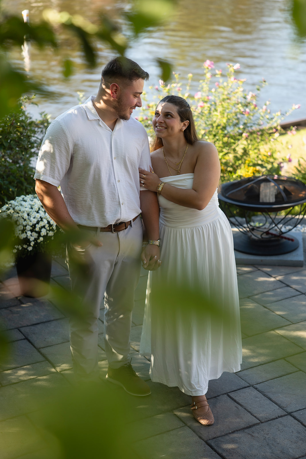 Andrew and Laura standing together beside the water